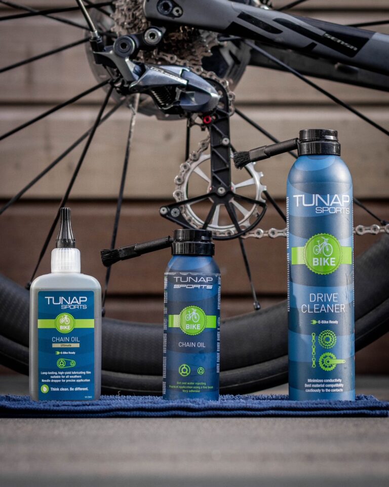 Chain Oil, Chain Oil Ultimate, and Drive Cleaner with rear wheel of bicycle in background